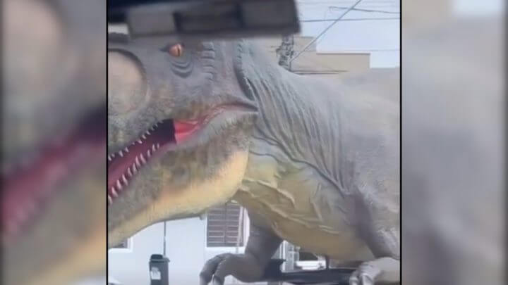 Dinossauro foi visto em cima de um caminhão passeando pelas ruas da cidade