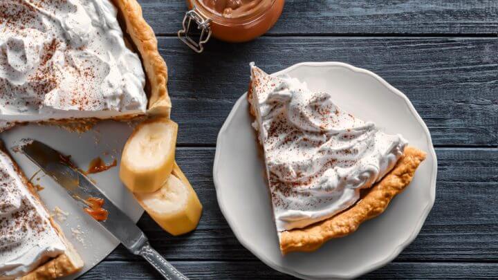 Fatia de torta de Banoffee em mesa de madeira com tom de grafite
