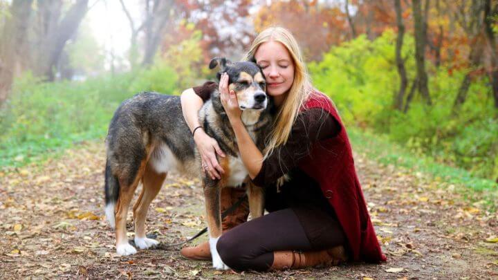 Mulher abraçando cão pastor alemão em parque