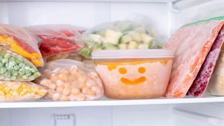 Comida congelada no congelador. Pote com desenho de sorriso.