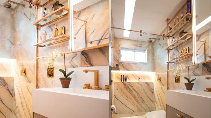 Duas fotos com a imagem de um banheiro com mármore branco e objetos decorativos em rosé gold