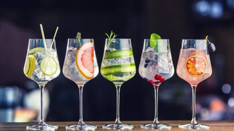 Taças de vidro com drinks em cima de uma bancada de madeira