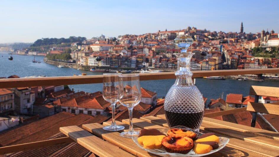 Mesa com vinho e pastéis de belém com vista para a cidade de Lisboa