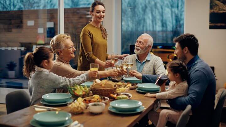 Família sentada ao redor de uma mesa jantando