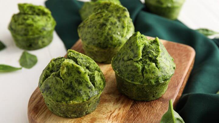 Três muffins de espinafre em cima de uma tábua