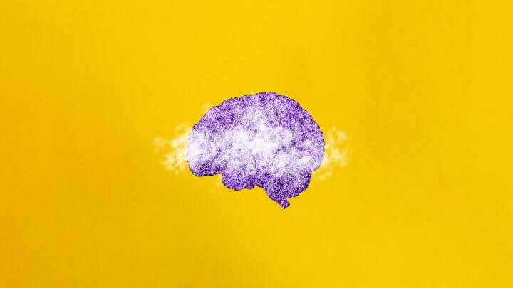 Ilustração de um cérebro roxo em um fundo amarelo com névoa sobre ele