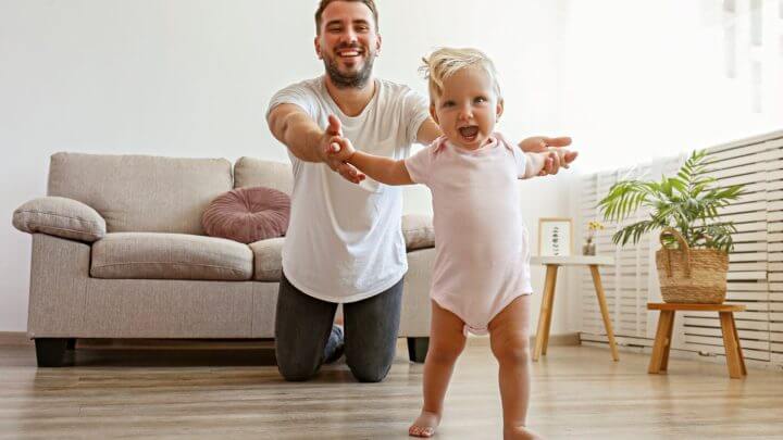 Pai brincando com filha na sala de estar