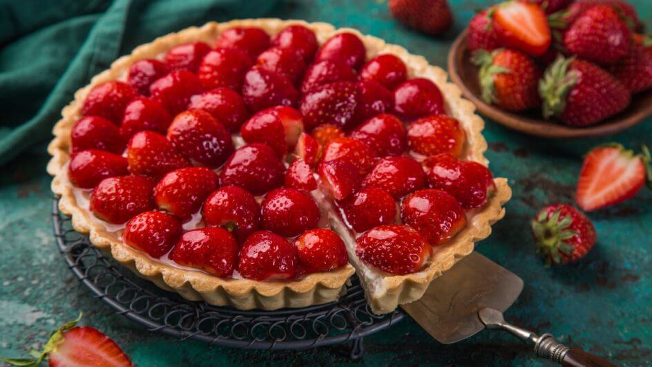 Espátula cortando o predaço de uma torta de morango