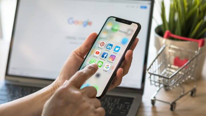 Mãos femininas mexendo em um celular com a tela na aba de aplicativos