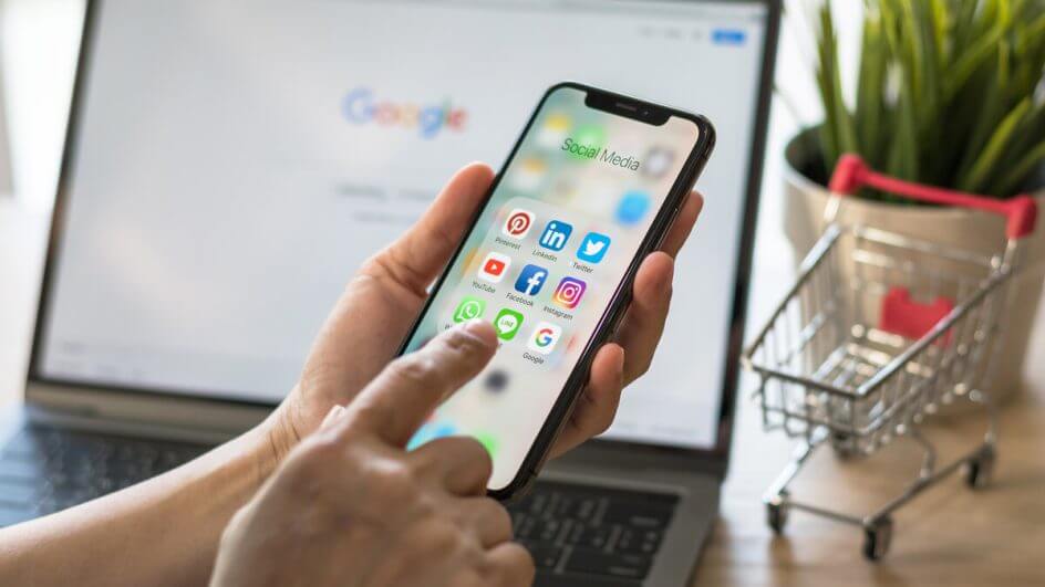 Mãos femininas mexendo em um celular com a tela na aba de aplicativos