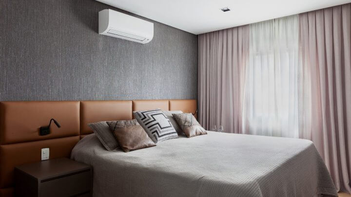 Cabeceira de cama revestida em couro sintético em um quarto cinza