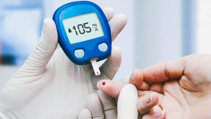 Médico fazendo teste de açúcar no sangue em paciente