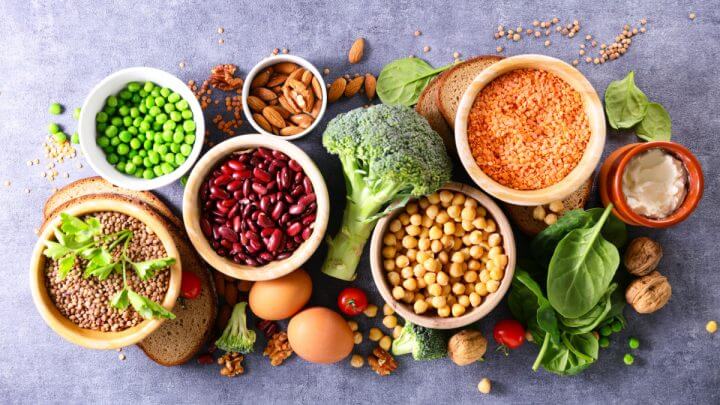 Alimentos ricos em proteína vegetal, como brócolis, rúcula, amêndoas, grão-de-bico, ervilha, nozes, ovos e mais