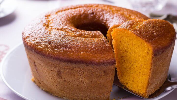 Bolo de cenoura em cima de um prato branco com um pedaço cortado