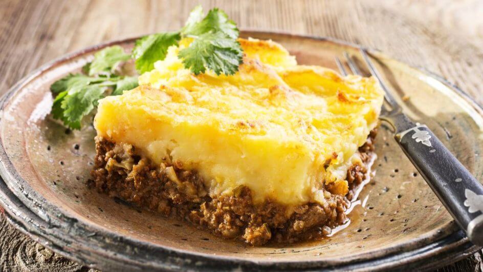 Prato marrom com um pedaço de escondidinho de carne moída