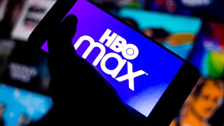 Logo da HBO Max na tela de um celular com uma mão segurando