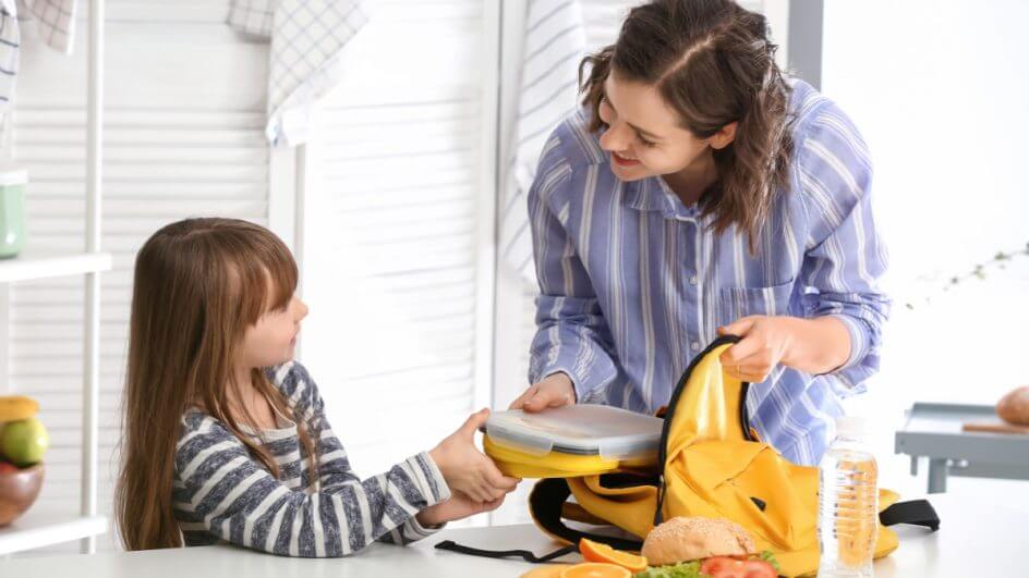 Mãe e filha preparando lancheiras juntas