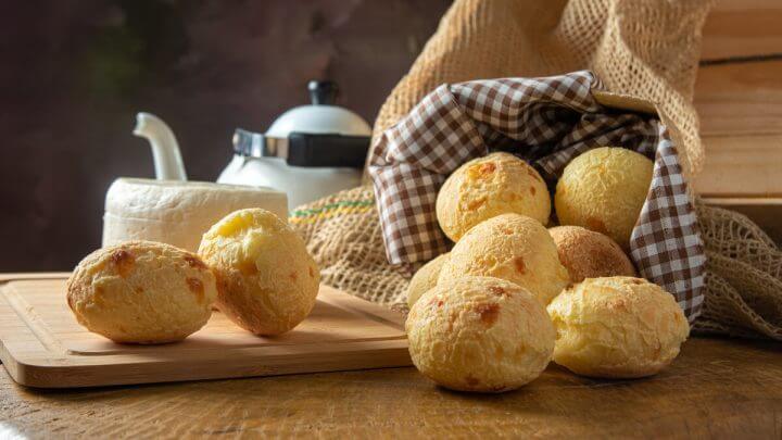 Pães de queijo em cima de uma mesa de madeira