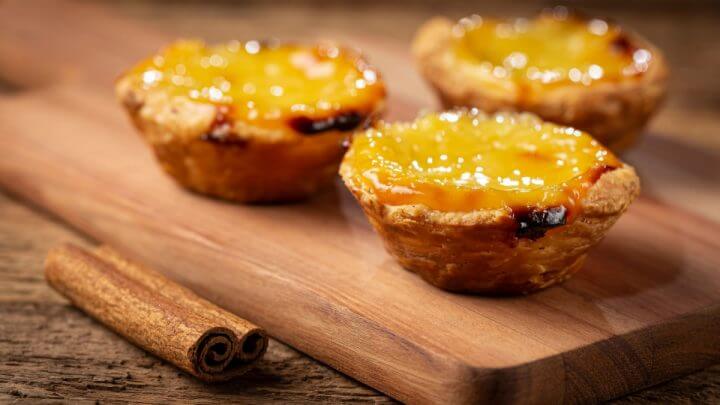 3 pastéis de nata em cima de tábua