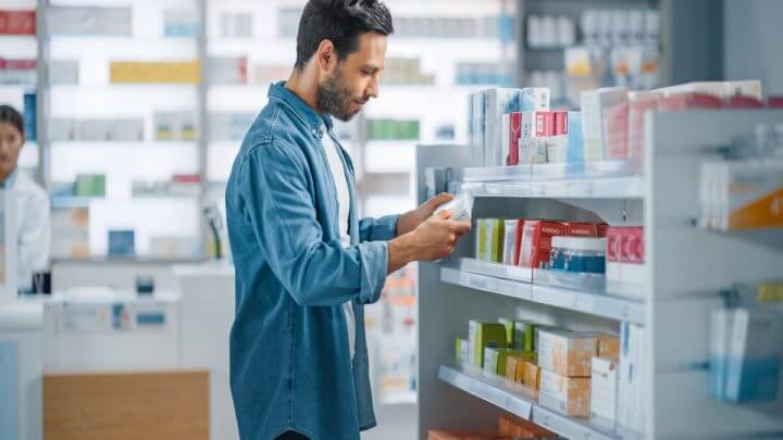 Homem em uma farmácia comprando remédio