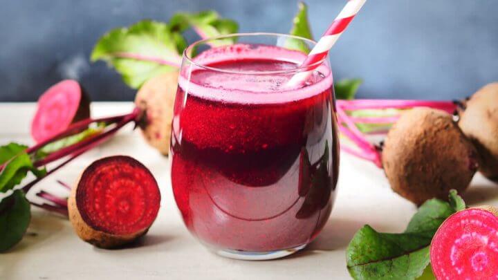 Suco de beterraba em um copo de vidro com canudo