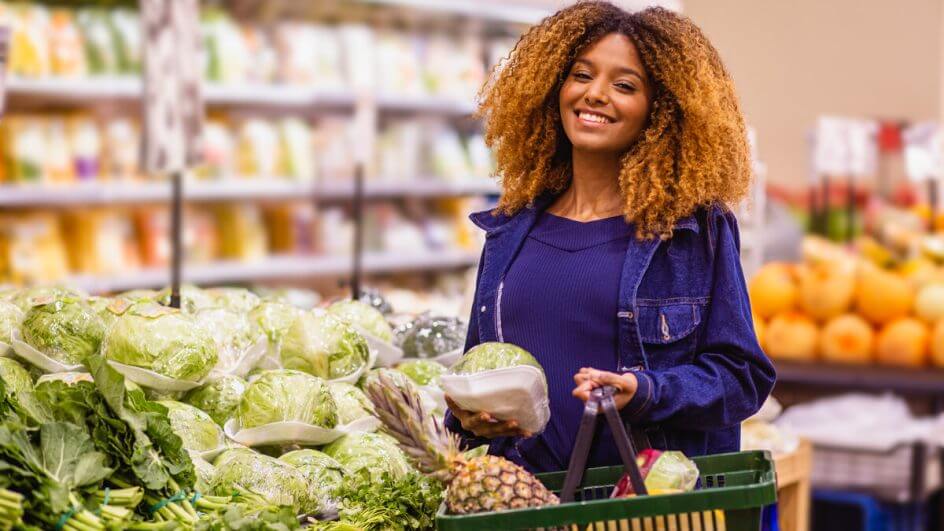 Mulher vestindo blusa azul fazendo compras em um supermercado
