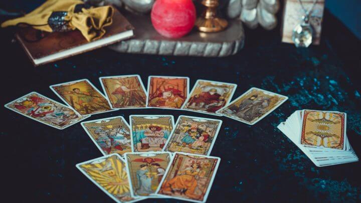 Cartas de tarot em cima de uma mesa com pano azul e velas