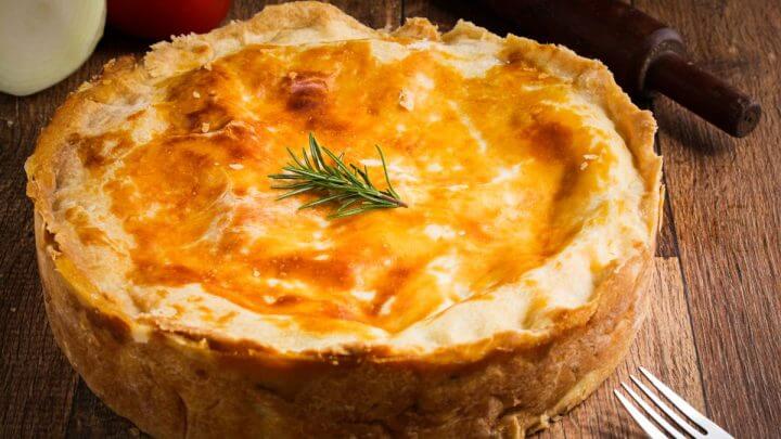 Torta de frango com creme de leite em cima de uma mesa de madeira
