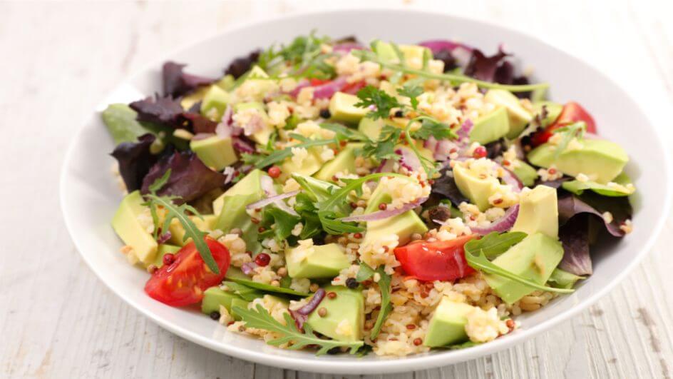 Salada de quinoa com abacate e tomate em prato branco
