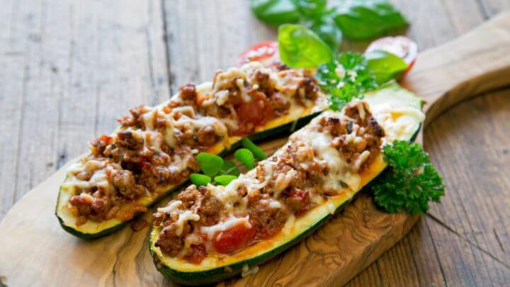 Duas metades de abobrinha recheadas com carne moída e queijo