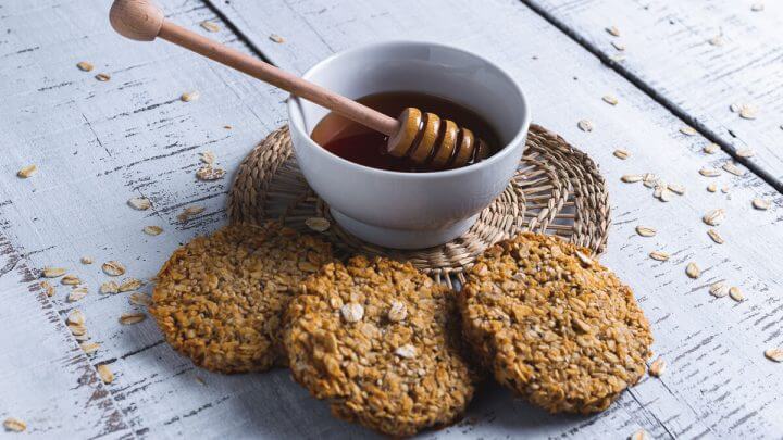 Biscoitos com chia em cima de uma mesa de madeira com mel