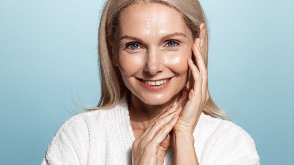 Mulher com as mãos no rosto sorrindo