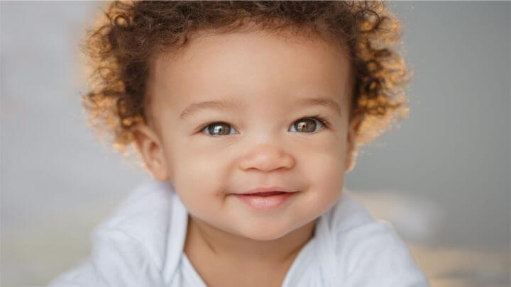 Bebê de cabelos cacheados sorrindo