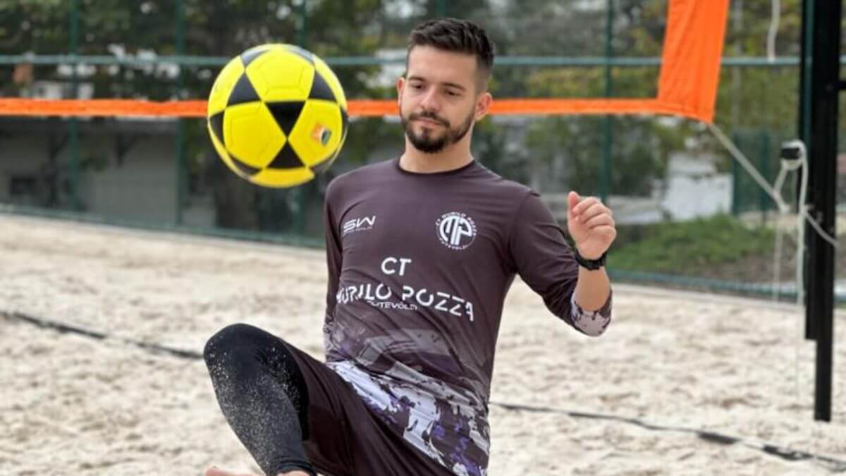 Imagem mostra homem vestido com camiseta e calça preta e uma bola amarela em frente