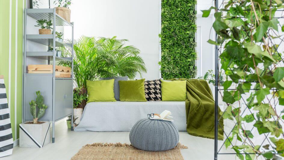 Sala de estar com jardim vertical, sofá cinza e tapete bege