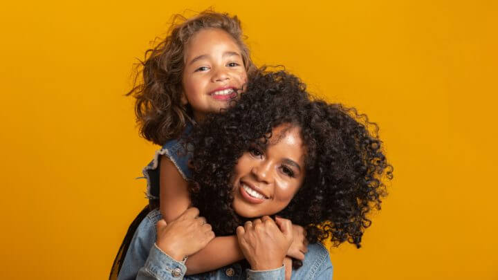 Mãe e filha abraçadas carinhosamente