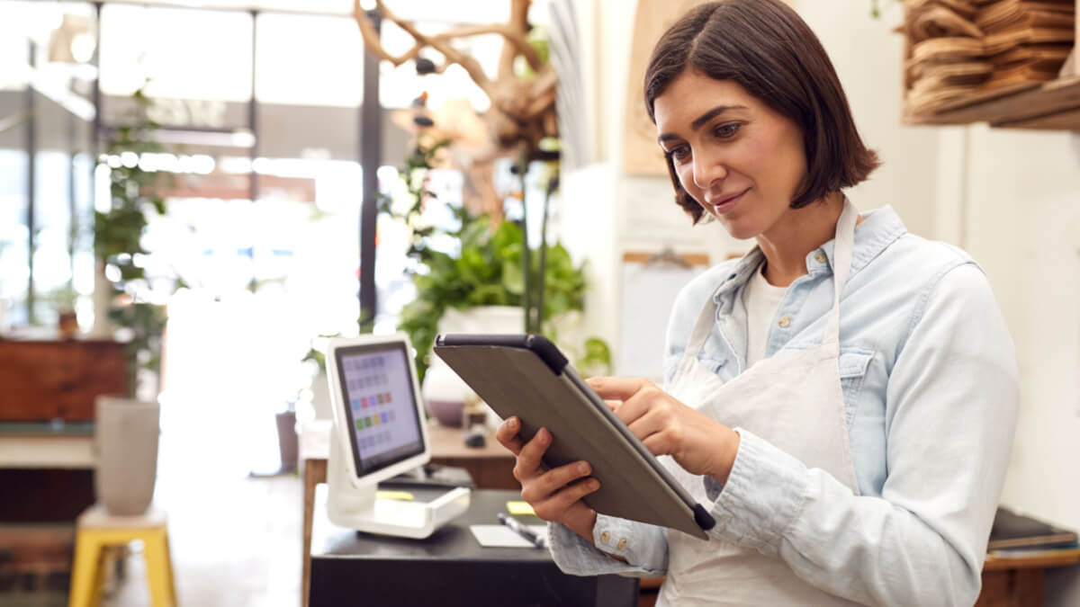 Mulher vestindo um avental e mexendo em um tablet