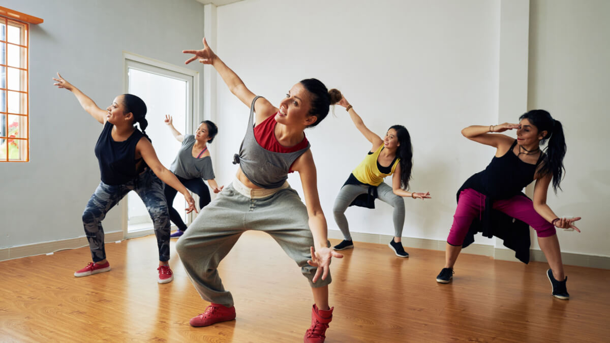 Cinco mulheres em sala fazendo aula de dança