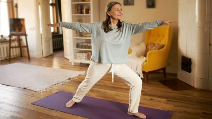 Mulher em cima de tapete praticando yoga
