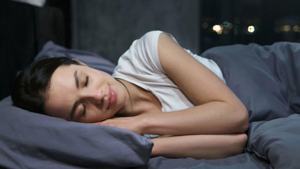 Mulher deitada em uma cama dormindo