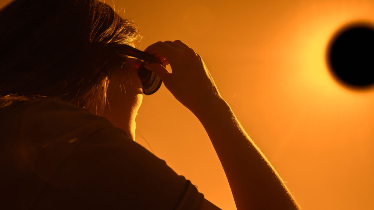 Mulher de óculos olhando para o eclipse