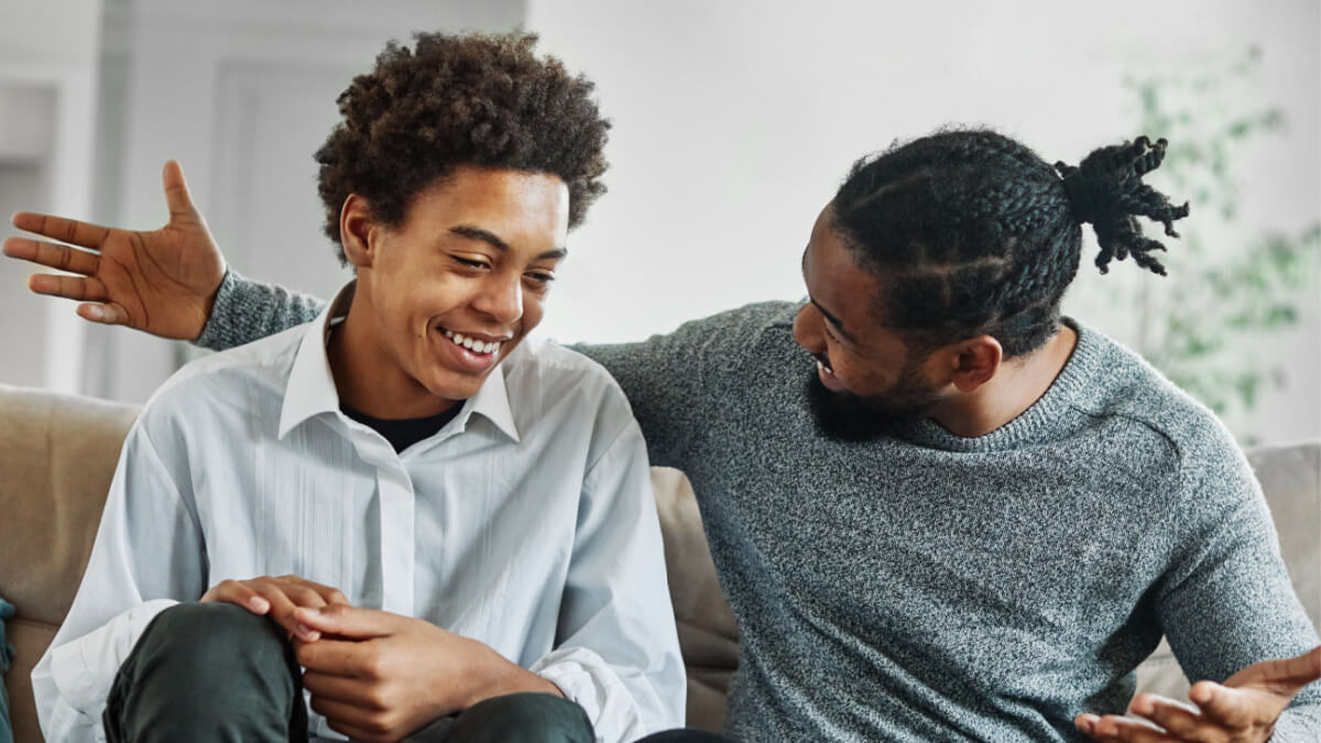 Pai e filho conversando harmoniosamente no sofá de casa