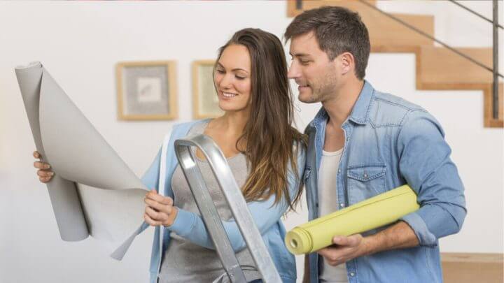 Mulher e homem olhando para um projeto de decoração e sorrindo