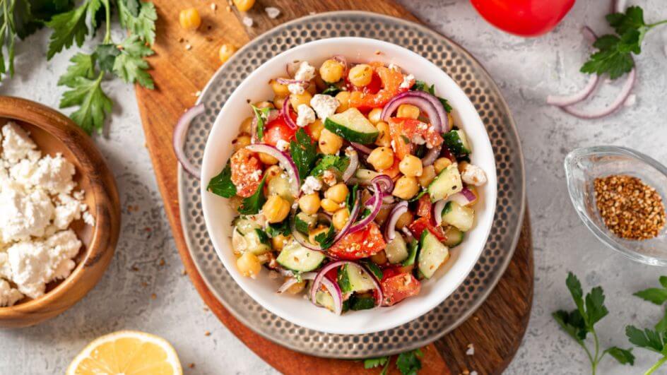 Prato de salada de grão de bico com ingredientes ao redor