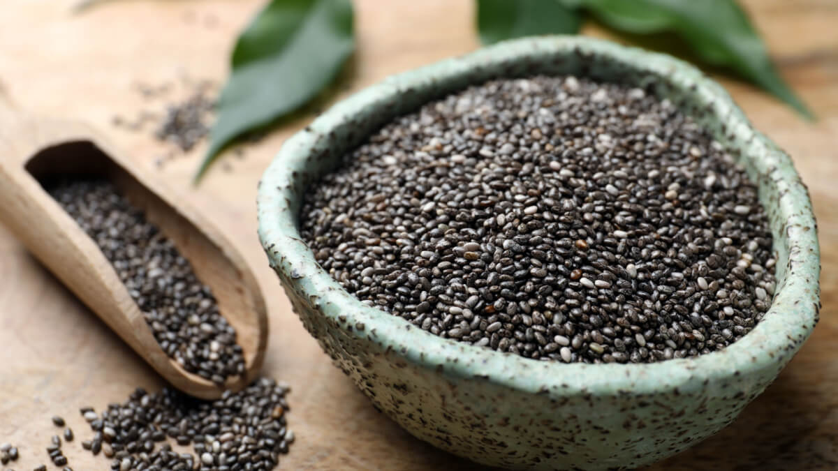 Bowl cheio com sementes de chia e sementes espalhadas ao lado
