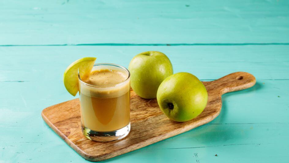 Suco de maça com gengibre em uma tabua de madeira