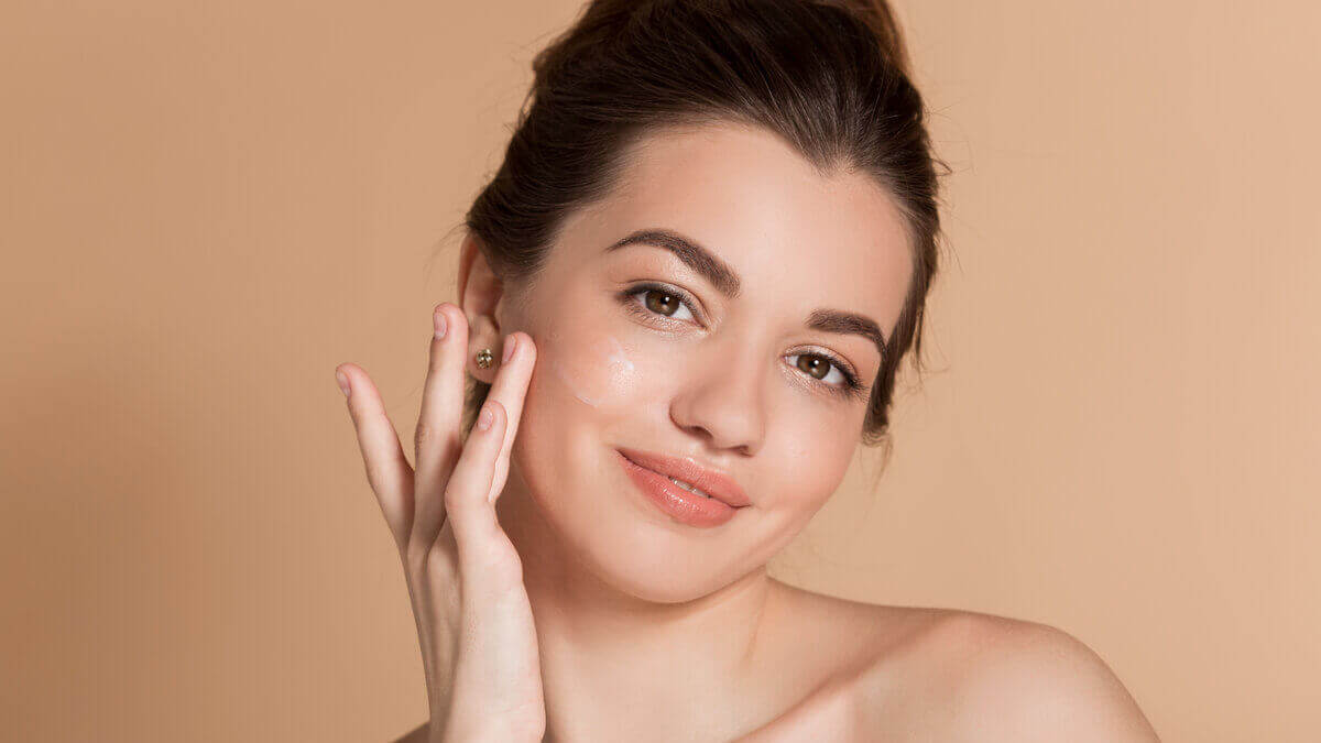 Mulher sorrindo com a mão na bochecha