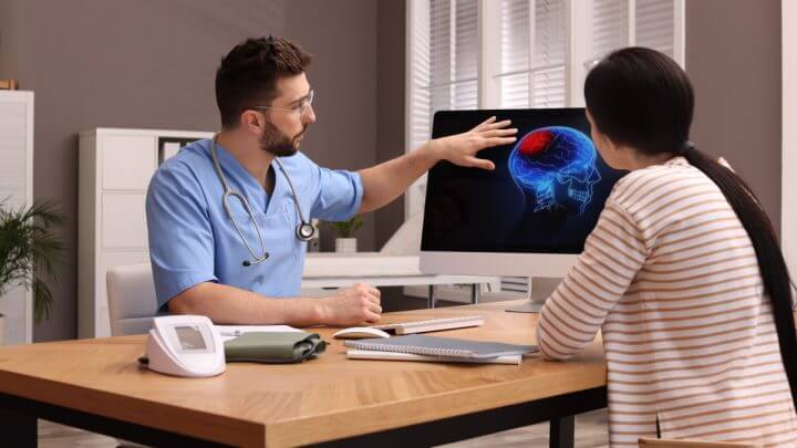 Médico e paciente analisando imagens de cérebro