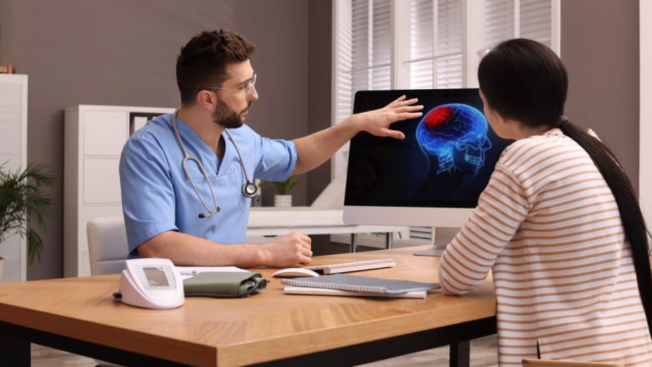 Médico e paciente analisando imagens de cérebro