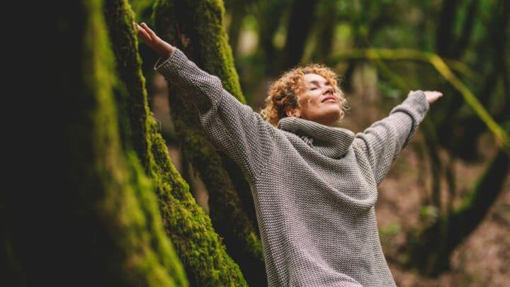 Mulher de braços abertos em natureza